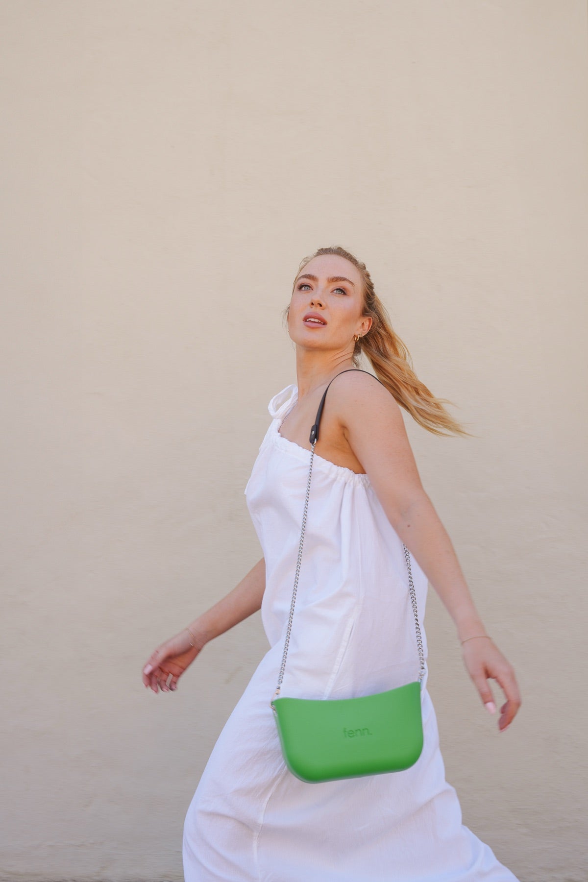 Woman in a white dress with a green FENN Petite